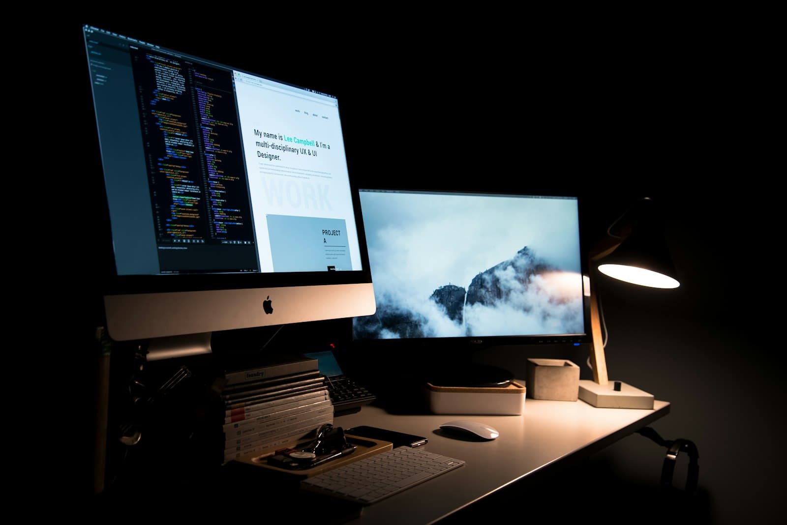 Designer's workstation with code editor and website design on screen